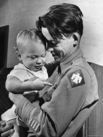 El Sargento del ejército Bill Mauldin sosteniendo a su hijo